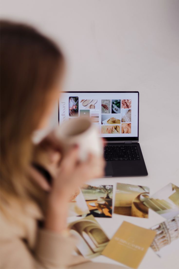 Reviewing a brand moodboard on a laptop, coffee in hand